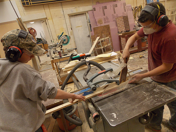 STARTING FROM SCRATCH: Sawing wood for the Variety Show, freshman Bryce Brennan and junior Justin Kalish prepare smaller pieces of wood to assemble the set. Every set design is created by Rich Winship, stage crew director. 
