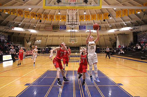 Passing Maine South defenders, Senior Captain Sarah McDonagh jumps for a lay-up (left). Carie Weinman, junior shooting gaurd looks for an opening to pass while defending the ball