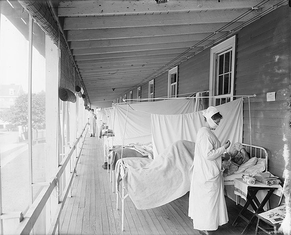 PANDEMIC PATIENTS: Aiding a patient at Walter Reed Hospital in Washington D.C., a nurse helps combat the influenza pandemic of 1918.  Photo from Wikimedia Commons