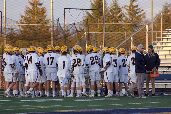 HUDDLE UP: Listening to new Head Coach Will Jeffery, the men’s lacrosse team receives advice at half-time during a game against Palatine on April 11; the Titans beat Palatine 15-2. Jeffery played lacrosse for GBS, and this is his first year coaching at South. 