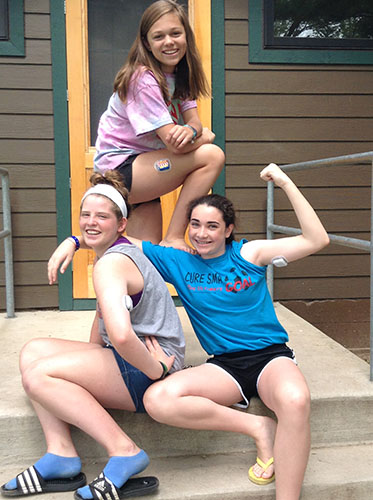 Standing outside of a cabin at an American Diabetes Association camp in northern Illinois, freshman Megan Stettler (top) and her fellow campers pose with their OmniPods, an insulin management system for type 1 diabetes. Stettler, as well as other South students, has worked to raise awareness and foster relationships with others affected by their illnesses. 