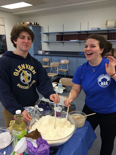 Posing while baking Challah, a traditional Jewish bread oftentimes served on holidays, junior Rebecca Spector, Israeli Club president, helps to mix the dough with sophomore Jake Hershenhouse. Israeli Club meets to discuss the prevalence of Israeli culture through activities and meetings. Photo courtesy of Rebecca Spector