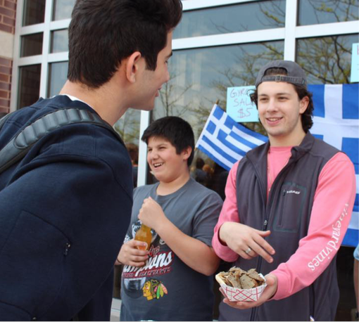 GRINNING GREEKS: Offering a traditional Greek dish to other students, senior George Maroutsos serves gyros to Spring Fling attendees. Other GBS clubs such as Girl’s Letter Club and Ciao Club made an appearance at the event.