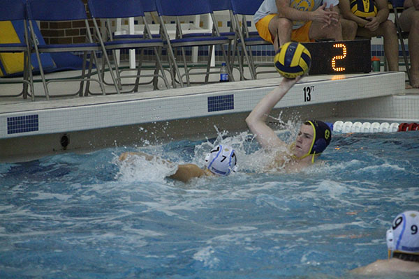 TOUGH TOMMY: Attempting to avoid a Maine West defender, senior captain Tommy Hagerty shoots the ball as the shot clock runs out during a game against Maine West on May 5. The Titans beat Maine West by a score of 11-5.