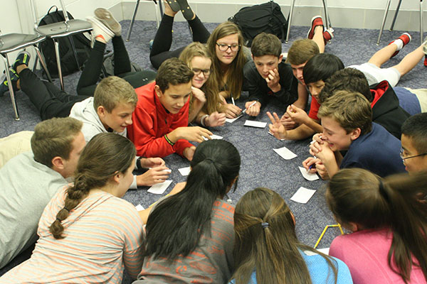 Breaking   the     Ice:  Huddling in a circle, South freshmen and their senior Peer Group leaders gather together during their designated Peer Group block. As a group, they work to form new friendships through teambuilding and get-to-know you games.