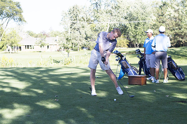 EYES ON THE PRIZE: Focusing on the ball, senior Robert Hopkins begins his  swing during a meet against New Trier. Hopkins finished the meet with a personal score of 40.  