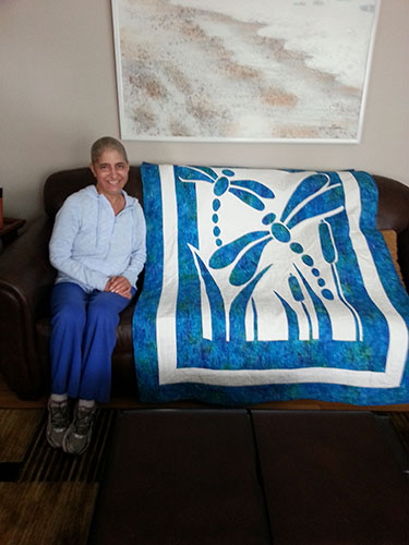 GRINS AND GIFTS: Appreciating her new present, science teacher Linda Kocian poses with a quilt given to her by fellow colleague Suzanne Webb as a “get well” gift. Kocian received lots of support from South’s staff when she was diagnosed with Multiple Myeloma. Photo courtesy of Jennifer Friedmann