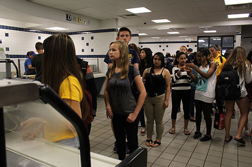 hungry   high   schoolers:   Queued up in the cafeteria, students wait to be served at food court stations. Quest has recently changed their policies regarding negative balances.
