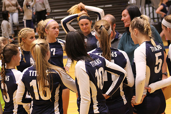 Huddle  in  for  the  win:  Listening to new head coach Kelly Dorn, the women’s volleyball team huddles and discuses their play after their win against the Niles North. The Titans played and defeated the Vikings on Sept. 27 ending by scores of 25-5 and 25-14. 