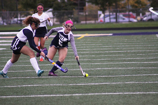 Lunging to avoid a defender, freshman midfielder MJ McNary, dribbles the ball down field during a game against F.W. Parker on Oct. 20. 