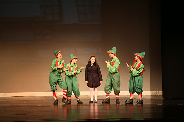 Miracle makers:   Pointing at freshman Abby Neptun, elves junior Erin Kirby, sophomore Becky Jacobson, freshman Luke Kirby, and junior Marina Madsen dance and joke with Neptun on stage of the fall play Miracle on 34th Street. The play’s storyline follows Kris Kringle, Macy’s hired Santa, who is soon put on trial after claiming he’s the real Santa Claus. 