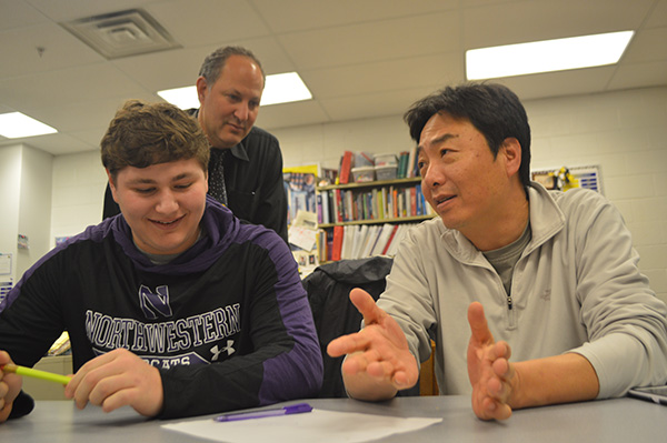 Father-son   Study   Session: Peering over his son Simon’s shoulder, math teacher Steve Farber checks over the work done by his son and math teacher Steve Yoon.  The teachers have sons who attend South, and all three pictured recognize the change of dynamic between father and son due to their teaching positions.