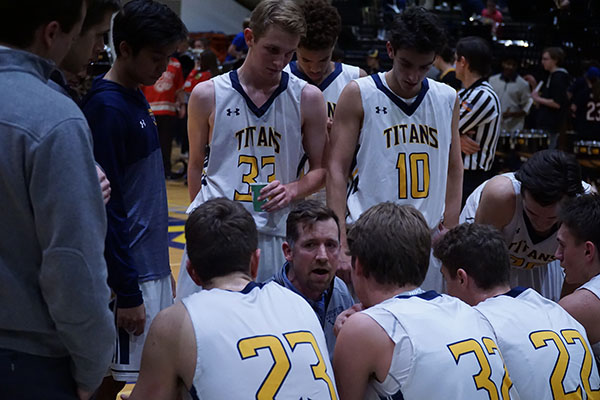 move   it,   maine   south:  Getting ready to take the court, head coach Ben Widner encourages the Titans during a timeout (left).  The Titan’s played against Maine South on Jan. 27 and lost the game with a final score of 56-44. 