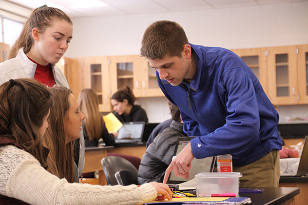 Methods   in   Motion:   Helping his students with a lab, Science Teacher Robert Cowhey explains the flow of electrical charge through a circuit. This year, Cowhey has not assigned any homework to his students, and he is one of several other teachers who have introduced unconventional teaching methods in their classes.