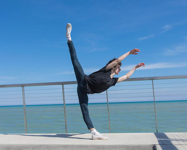 LOUNES BY THE LAKE:  Bending forward with one leg in the air and his arms spread out, junior Lounes Landri executes a Penché. Landri started dancing when he was in seventh grade, and this summer, he will be attending a summer program at The Juilliard School. 
