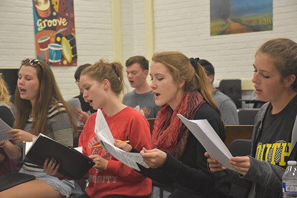 CHIMING CHAMBERS: Singing intently, (from left to right) juniors Steph Ornduff and Becky Jacobson, along with seniors Erin Kirby and Rachel Shwartz, prepare for future shows they will perform in within their a capella group, Chambers. This ensemble is best known for their old fashioned clothing and seasonal songs. 
