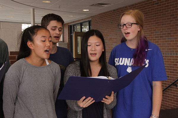 SERENADING SCAT THAT: Reading their music intently, (from left to right) sophomore Jenna Kim, seniors Micheal McNeela and Yenny Ha and junior Ellie Eavenson sing in South’s only jazz group, Scat That. This group is directed by co-choir director Andrew Toniolo, pictured above.
