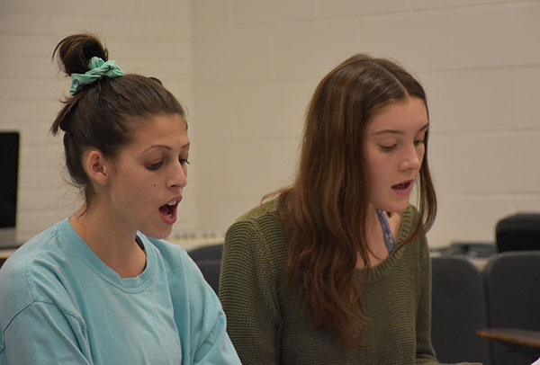 SYMPHONIC SOLACE: Matching pitch, seniors Ashley Levenson (left) and Claire Valenziano (right) practice in their all girls a capella group, Solace. This group is directed by Robert Shellard, new co-choir director. 