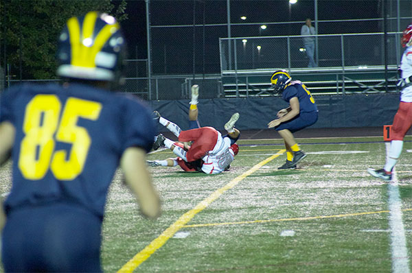  Running towards a tackle, junior Charlie Mackimm looks to help his teammate against Niles West on Sept. 28. The Titan’s will hit the turf again tonight at Maine South. 