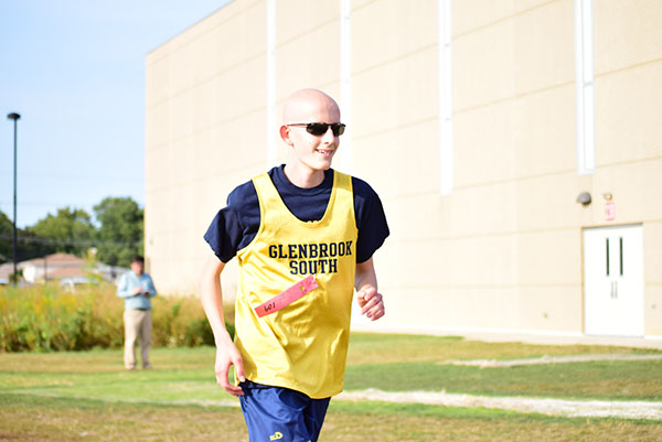 Running in a cross country race, freshman Luke Gregory smiles toward the finish line. 