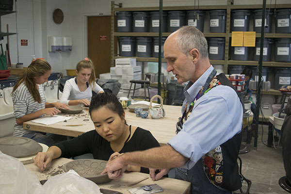 WONDERFUL WEBB: Ceramics teacher Kurt Webb instructs a student on her ceramics piece. Webb says he developed his passion for art at a young age.