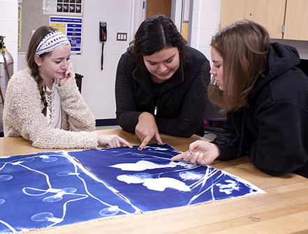 Creatively Collaborating: Critiquing a photo in class, juniors (from left to right) Mara Mazzuccheli, Lauren Zylke and Abby Kwit work together on a piece. Starting with Photography 1 and ending with Photography 8, these classes increase in both difficulty and freedom given to students with each additional level. 