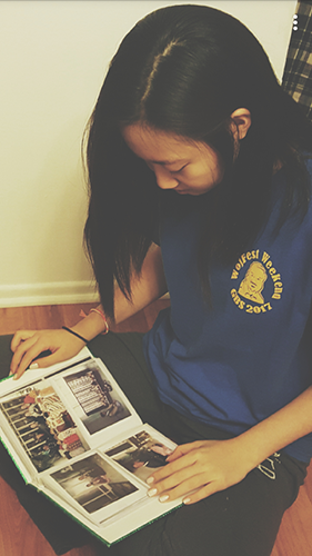 Junior Isabel Baik looks at family photos of her relatives in Korea. Baik believes the distance between her family allows her to appreciate each moment they are physically together.