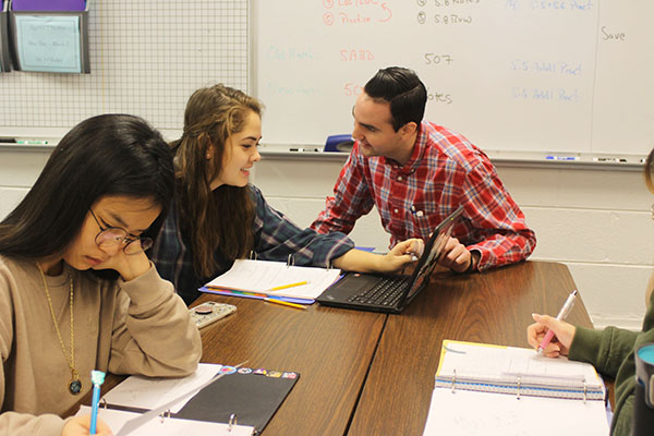 OUTGOING O’MALLEY: Sitting with his students, Mathematics Teacher John O’Malley helps freshman Sabrina Penepacker with her work. O’Malley received the Illinois Promising New Teacher of Mathematics Award for his creative and interactive method of teaching. 