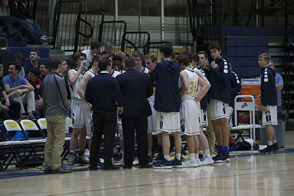 Head Coach Phil Ralston talks things over with the team during a time out against the against the Niles North Vikings on Jan. 26th (left). Junior guard Will King releases a free throw against the Vikings in the second half of the Titans contest aginst Niles North. The Titans fell to the Vikings by a score of 58 to 36.