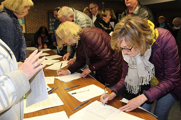 FIGHTING FREIGHTS: Signing a petition at a public forum held in the Watson Auditorium, Alliance to Control Train Impacts on Our Neighborhoods (ACTION) committee members express their opposition to the building of a new Amtrak freight train line. Local residents have voiced their concerns about the impact it could potentially have on Glenview neighborhoods, GBS, and the environment. Photo courtesy of The Village of Glenview