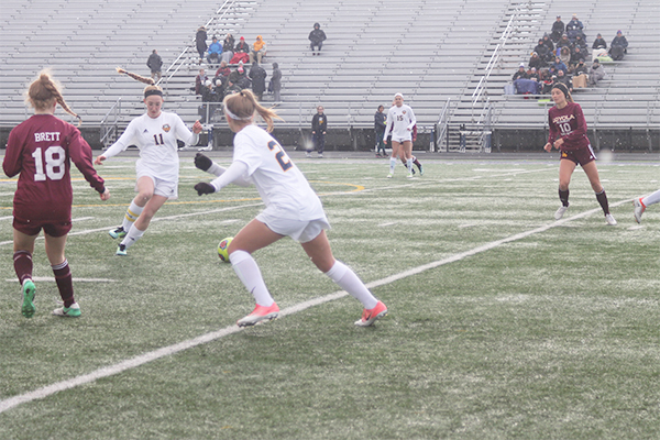 MEIER ON THE MOVE: Moving out of the way, sophomore Katie Weiss assists captain Lauren Meier as she dribbles away from a Loyola player. The Titans game against Loyola was an important one because it kept both teams undefeated. 
