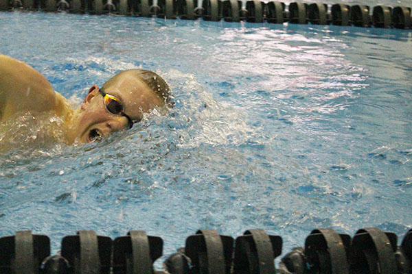 Completing his stroke, junior Zach Spalding competed at the Titan Senior Night.