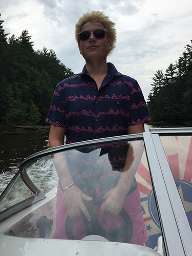 LEGALLY BLONDE: Driving a boat, sophomore Graham looks ahead as the wind blows his blonde hair back. Graham bleached his hair in the summer of 2016: just one of his many phases.