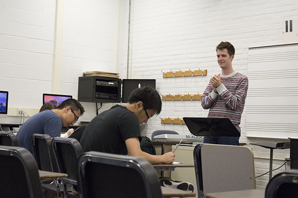 RHYTHMIC RITUAL:  Clapping his hands, Robert Shellard, AP Music Theory teacher, warms up his AP Music Theory class with an exercise where the class is prompted to write down whatever melody or rhythm Shellard plays. This is one skill of many that was present on the students’ AP tests at the end of the year. 