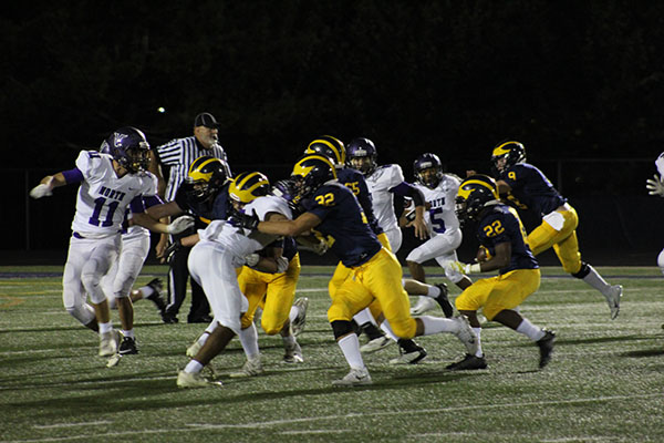 Blocking the Niles North defense, the Titans protect sophomore Zack Herndon (22) as he attempts to score a touchdown. The team played Niles North for their homecoming game on Sept. 21 and won by a score of 41-0. 