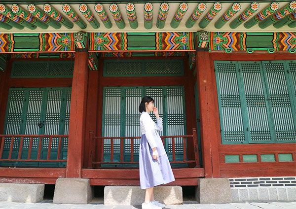 Happy Homes: Giggling in her country of origin, sophomore Seonghyun Kim poses in front of a building in South Korea.
