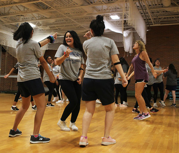 A For Effort: Dancing in PE class, junior Leila Khakpour (facing center) uses a heart rate monitor to track her activity level. At the end of last school year, heart rate monitors were introduced in some PE classes, and their use is continuing this year in freshman and sophomore classes. 