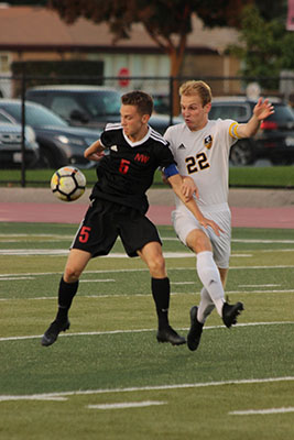 Defending a Niles West player, senior Gavin Morose fights for the ball. 