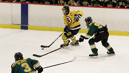 Sprinting across the ice pursued by a North player ready to defend, junior Theo Papalas stays in control of the puck. The boys lost to North 2-5 on Nov. 21, but plan to make changes in their game in order to make it far in the playoffs, according to senior Max Abramov. 

