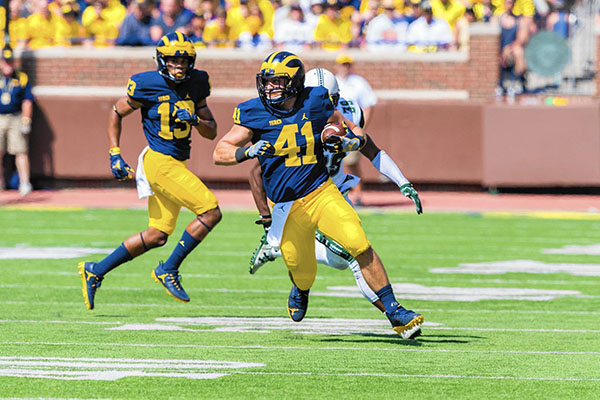 Running down the field, South alum Mike Hirsch makes his first play as a Wolverine. Hirsch graduated from GBS in 2010.