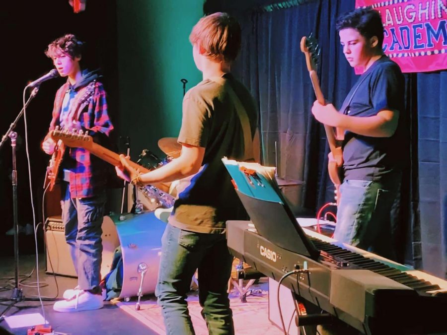 Guitar greatness: Rocking out at the Laughing Academy, a local improv school, sophomores Henry Najem, Terry Treger and Johnny Rolfes (left to right) play during the summer of 2020. More recently, their band, Candy for Breakfast, won Battle of the Bands, a competition at South between various bands where students vote for a winner. Photo courtesy of Johnny Rolfes.