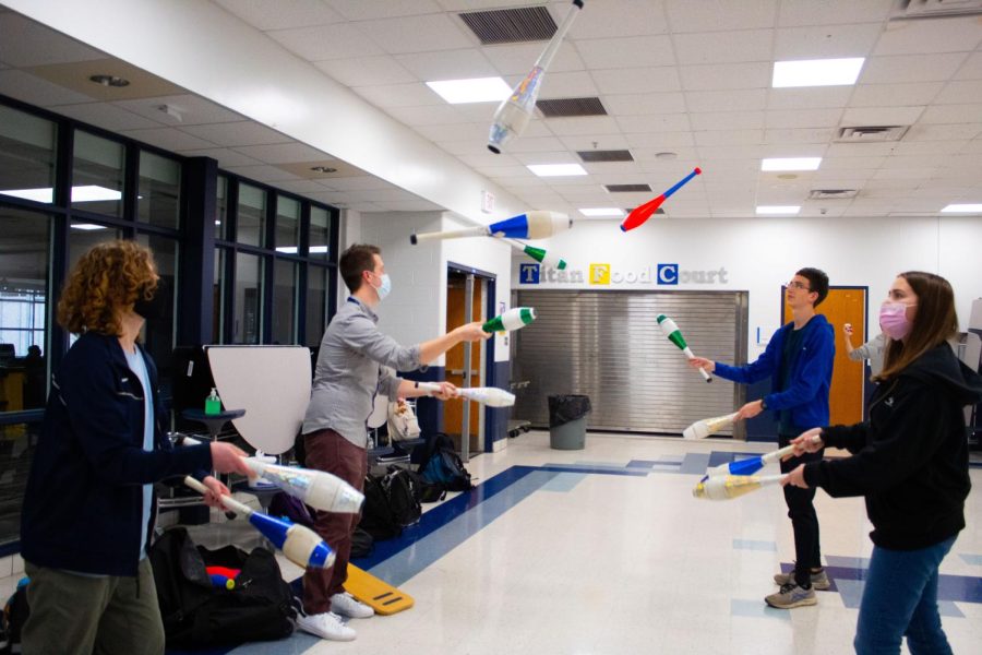 Group Act: Sophomore Meredyth Herrera (left). Michael Sinde (second from left), and seniors Peter Nardulli (second from right) and Penny McNeela (right) practice tossing clubs to each other. Photo by Sofia Oyarzún