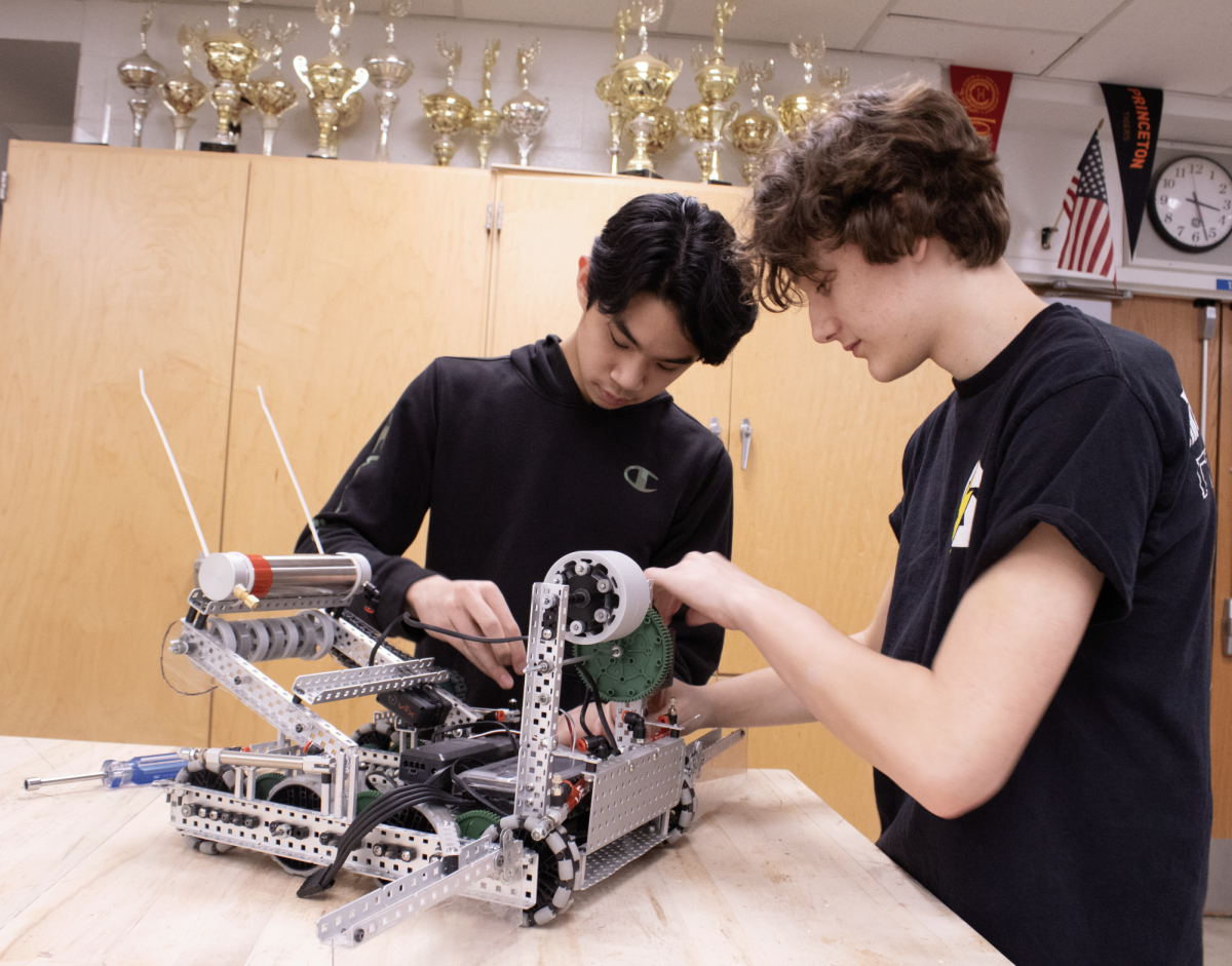 Sophomores Phillip Yong (left) and Austin Rudd (right) modify their team’s robot, C-3POE, in anticipation of the State competition.