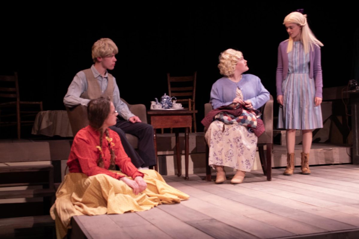 Off the Page: The Johansen family, portrayed by Amy Patton (seated left on the floor), Charlie Chasen (seated left on the chair), Shayna Fitzershtein (seated right on chair), and Isabel Arranz (standing right), talk about the recent closings of Jewish stores in their town. The spring play includes many scenes , such as this one, that are identical from the book to the stage adaptation. 