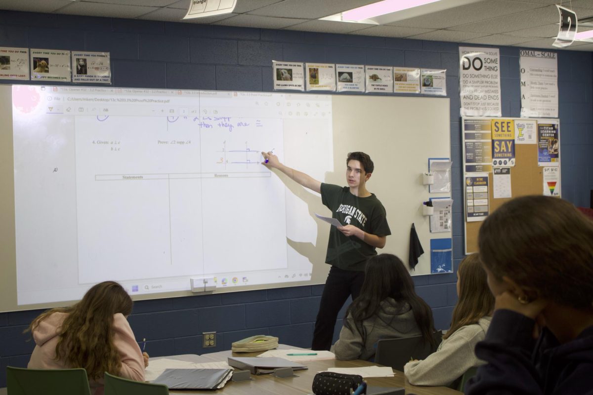 ASSISTANT IN ACTION: Sophomore Kenneth McCarthy, TA for Honors Geometry, helps teach the
students. The students attentively watch McCarthy as he explains how to solve a proof.
Photo by Andrew Collaku.