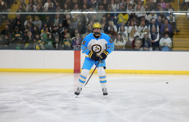 RINKSIDE BOND: Junior Luke Fagin (top) and junior Will Fagin (bottom) stand ready to fight for the puck after the face off at the South versus North varsity hockey game on Nov. 26. The twins had one shift together, though South fell short in overtime for a 3-2 loss.