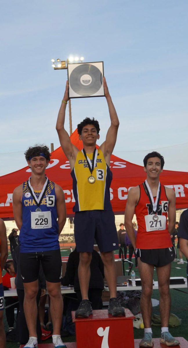 RUNNING CHAMP: Senior Junior Lopez holds up his award after winning the 1,600-meter race with a time of 4:16.99. Lopez also broke the school 1,600-meter record by 3.48 seconds in the same race.