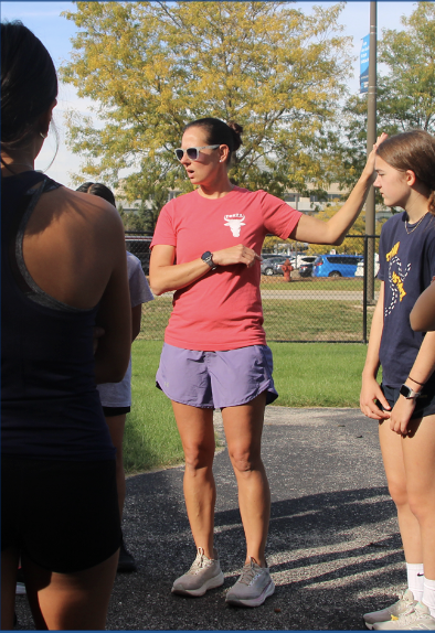 FINDING HER STRIDE: Melissa Coughlin, Girls’ Cross Country Head Coach, instructs her runners at a practice session. The team is adjusting to new training routines as Coughlin steps into her first season leading the program.