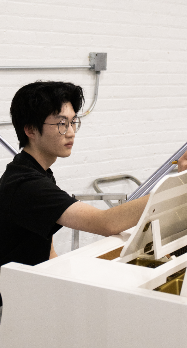 CURATING CREATION: David Cha sits at a piano, one of his workplaces while he brainstorms ideas for his musical pieces. His works are classical, inspired by impressionism and modernism. 