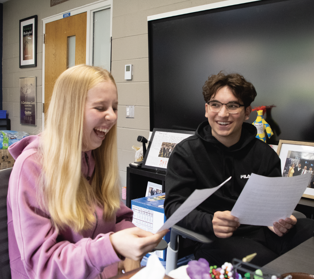 BEFORE THE BELL: Ariella Magnus, Sophomore Appointed Representative (left), and Kenneth McCarthy, Senior Class President (right), do a run-through of the script for the morning announcements before they go live. The two are reading the script  for the first day of Homecoming Week. 